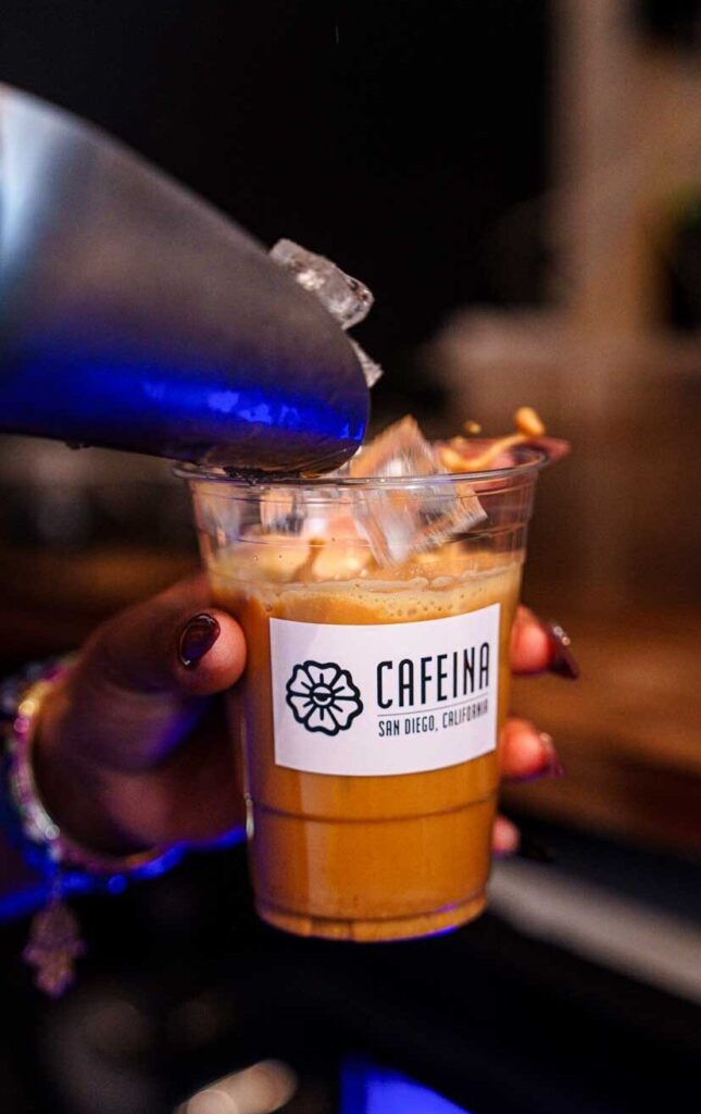 Pouring Ice into a cup of coffee